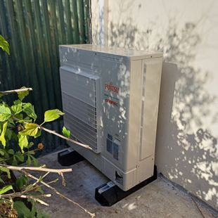 Pompe à chaleur installée contre le mur d'une maison individuelle