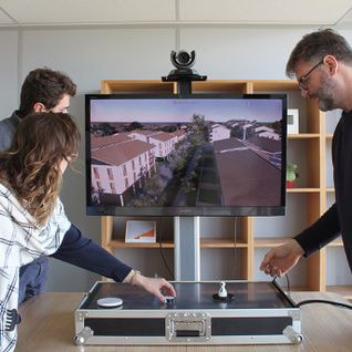 3 personnes en train de faire de la planification urbaine autour d'une table numérique qui modélise la ville en 3D